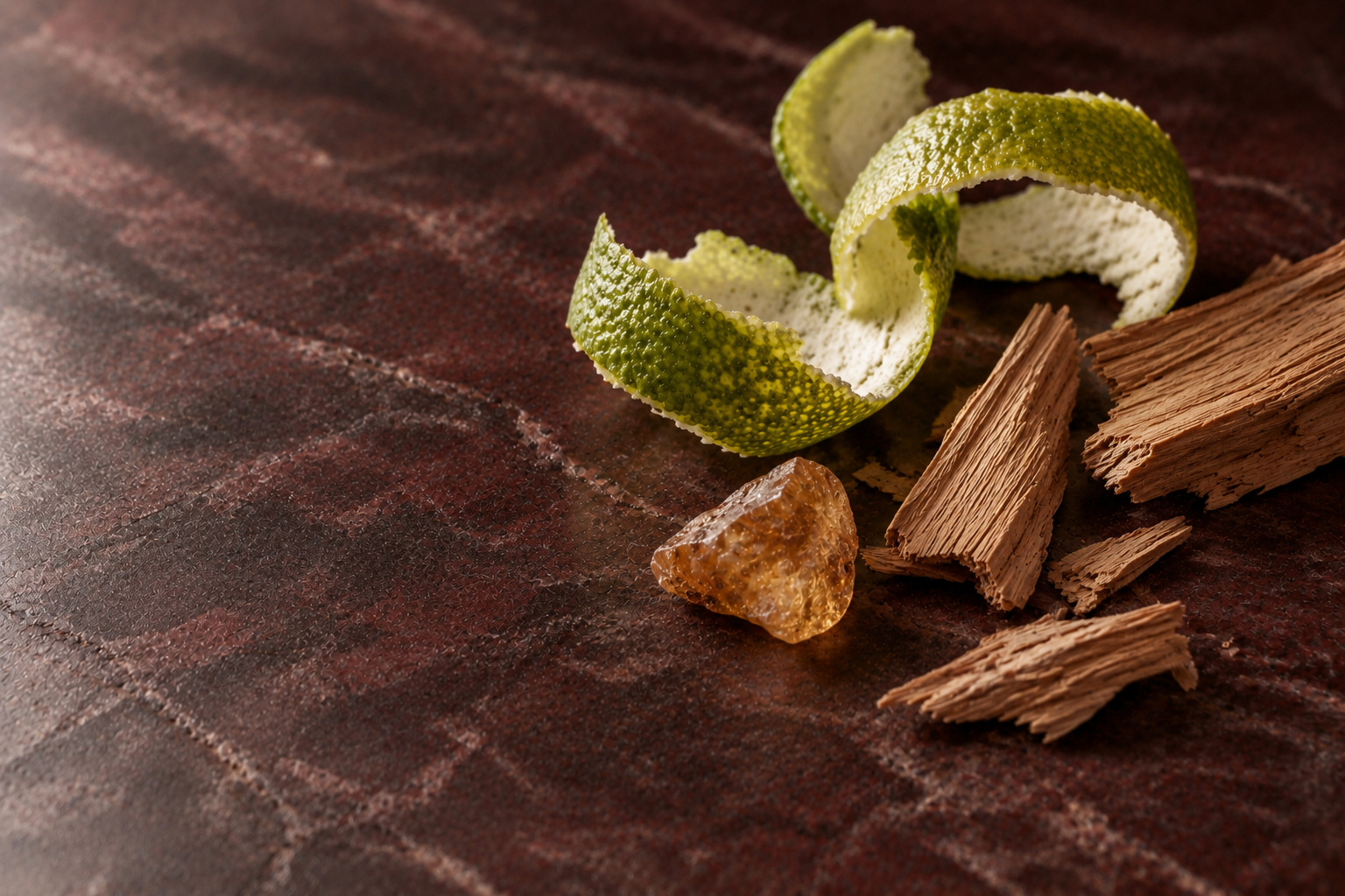 Bergamot peel, cedar shavings and amber-coloured resin on deep burgundy stone